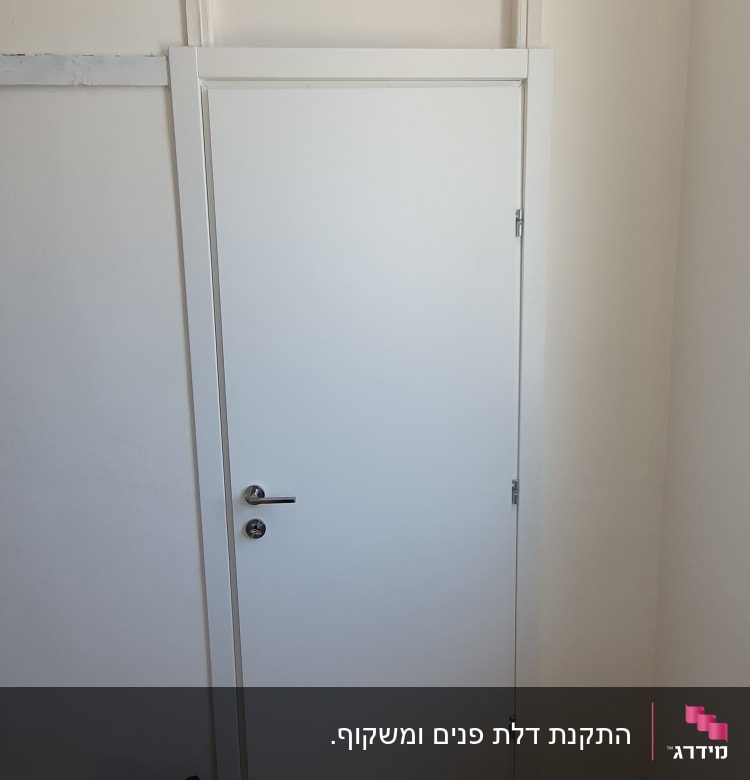 דלת לבנה עם ידית מתכת, מקדחה על הרצפה